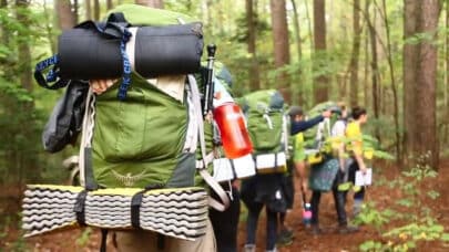 A group of people backpacking through a forest.