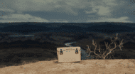 A white cooler sitting on top of a rock.