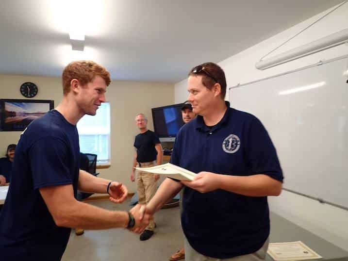 Two men shaking hands in a classroom.