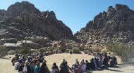 A group of people sitting in a circle in joshua tree national park.