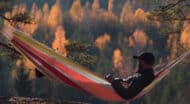 A man relaxing in a hammock in the fall.