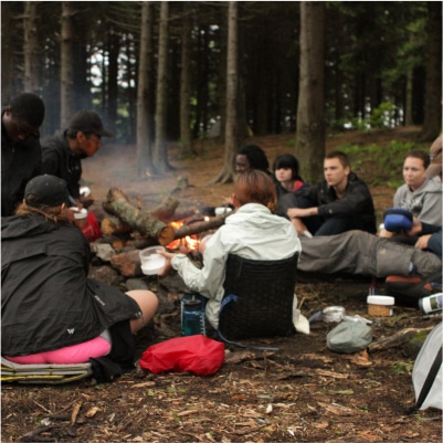 A group of students gathered around a campfire.