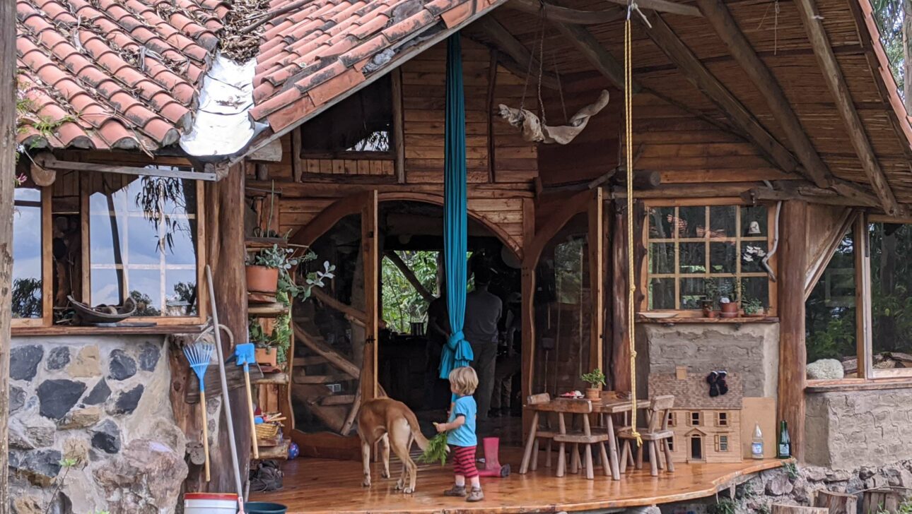 A young boy and dog at the entrance of a house in Ecuador.