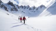 A group of people cross country skiing in the mountains.