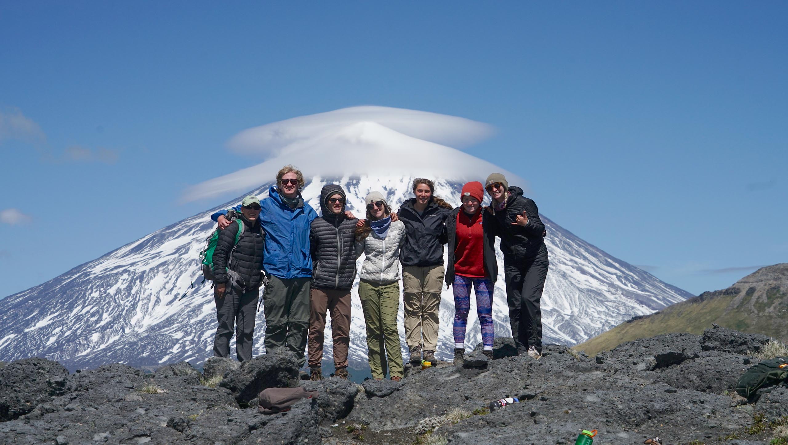 A group of people with a view of a snow capped mountain in the background.