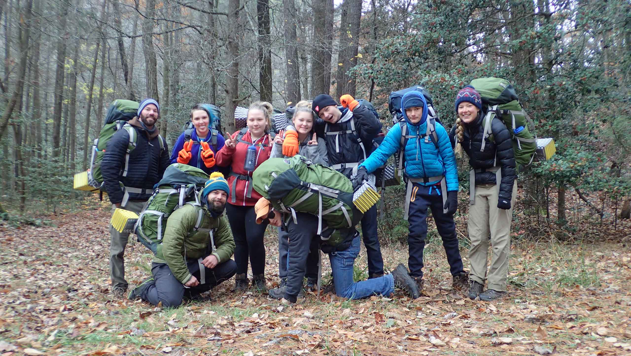 A group of students smiling and wearing expedition gear.