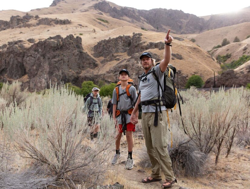 Two students following an NCOAE instructor on a hike.