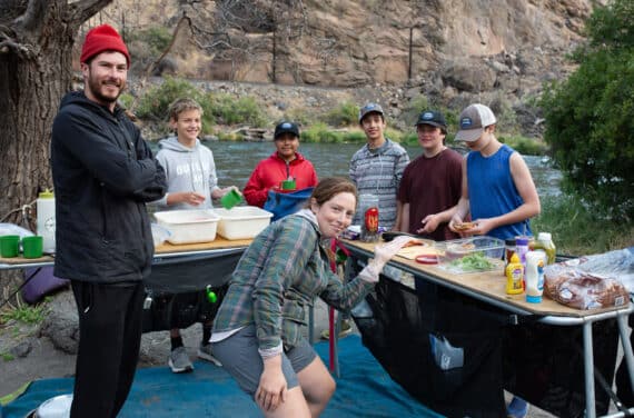 A group of students and instructors preparing a meal.