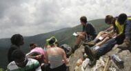A group of people sitting on top of a mountain.