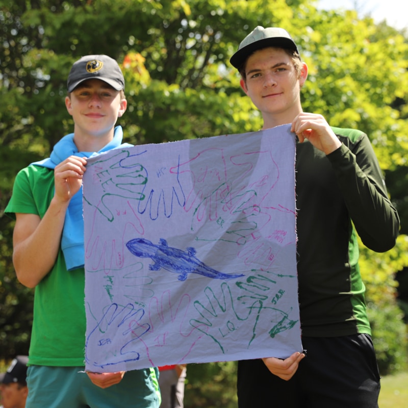 Two students holding up a fabric poster.