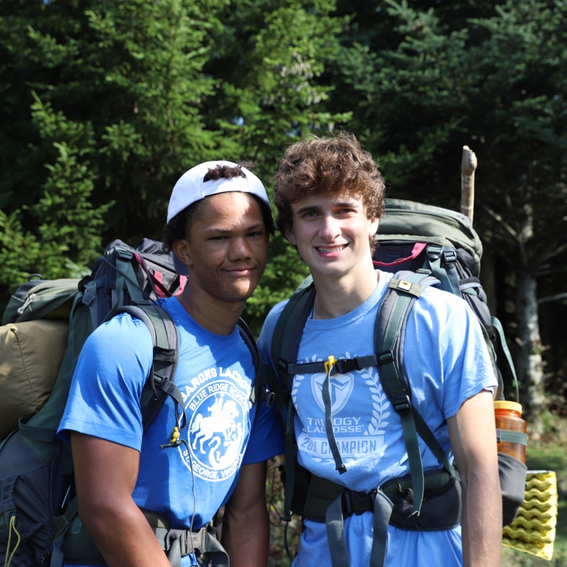 Two students wearing backpacking gear, smiling.