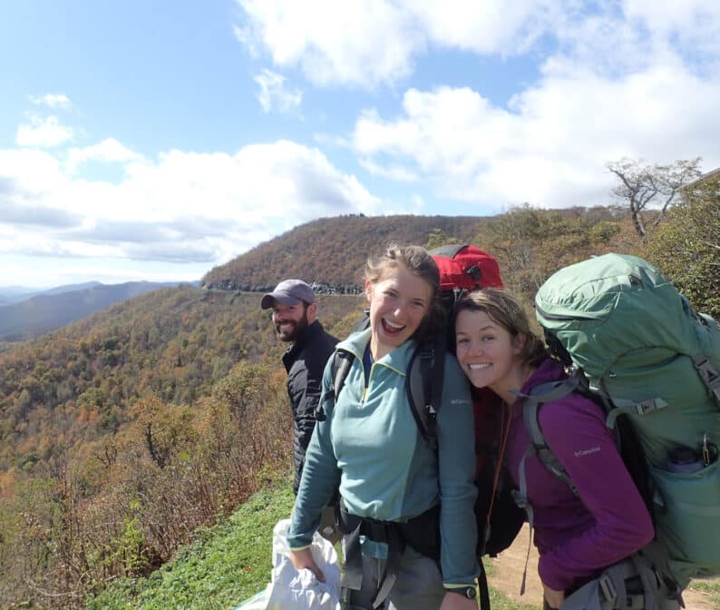 Three people with backpacking gear, smiling.