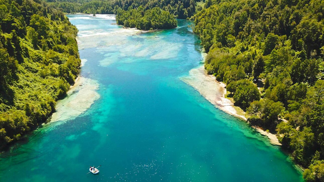 An aerial view of a body of water and a whitewater raft.