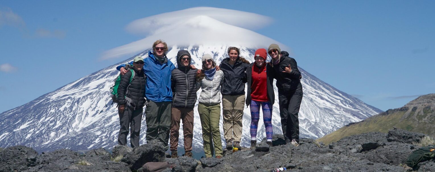 A group of people with a view of a snow capped mountain in the background.