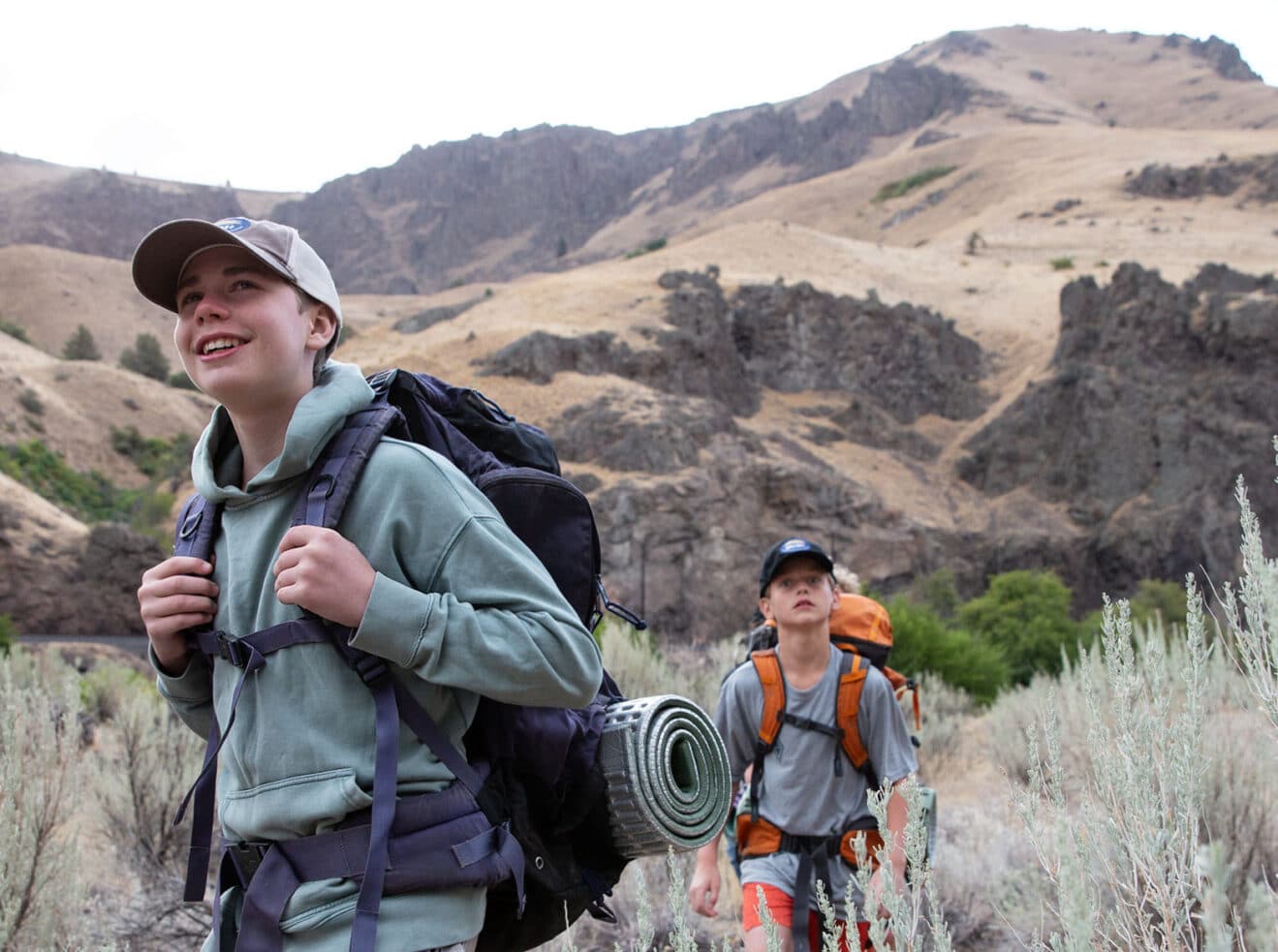 A boy with backpacking gear.