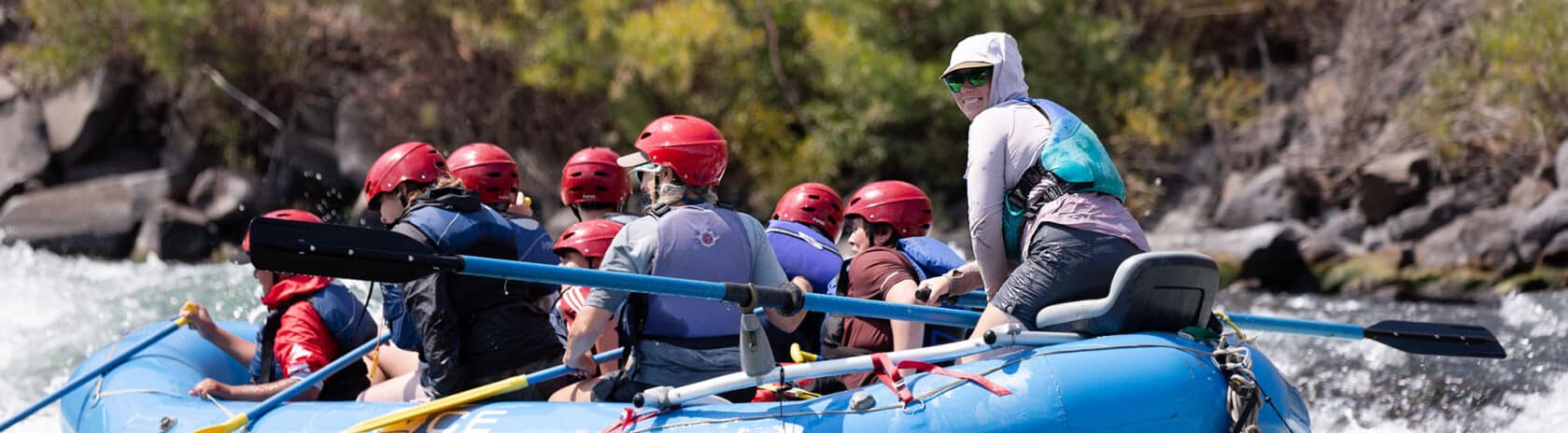 A raft guide overlooking students on a raft.