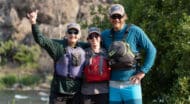 Three adults in hiking gear, smiling.