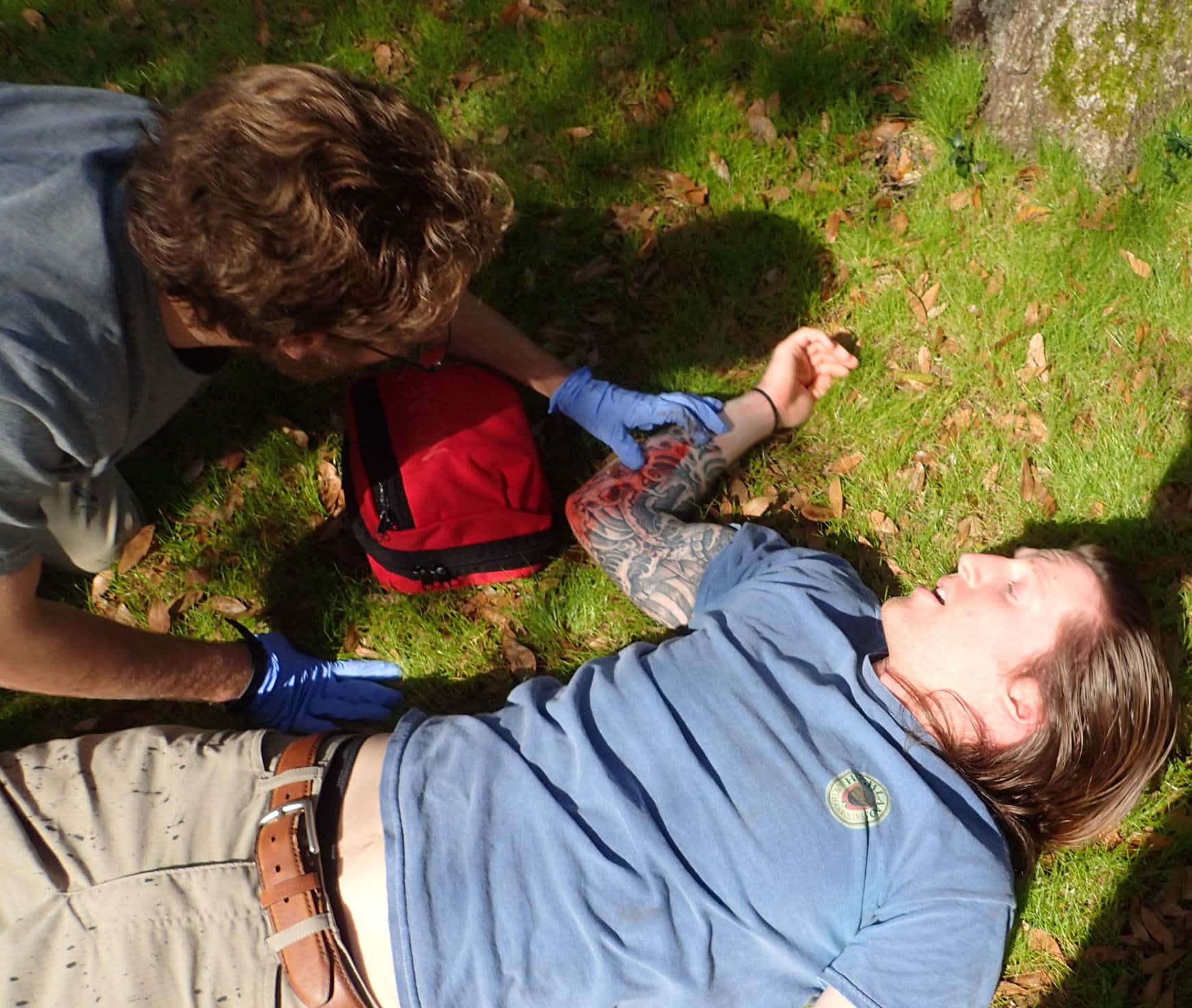 A wilderness medicine personnel examining a patient in a field.