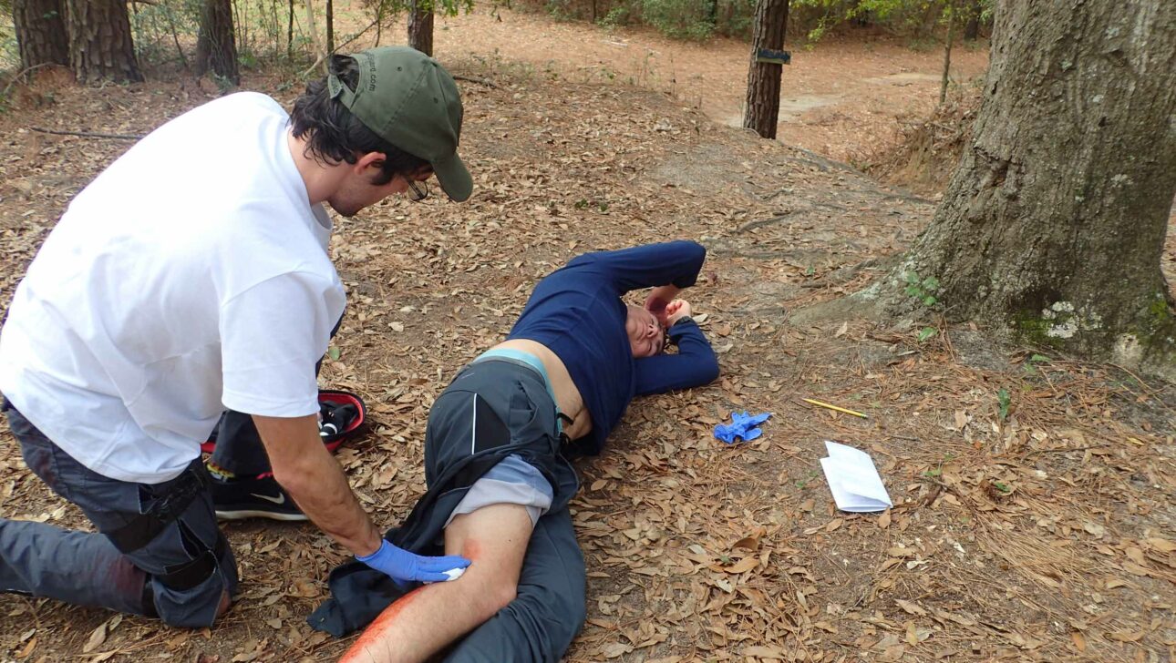 A wilderness medicine personnel treating a leg injury.