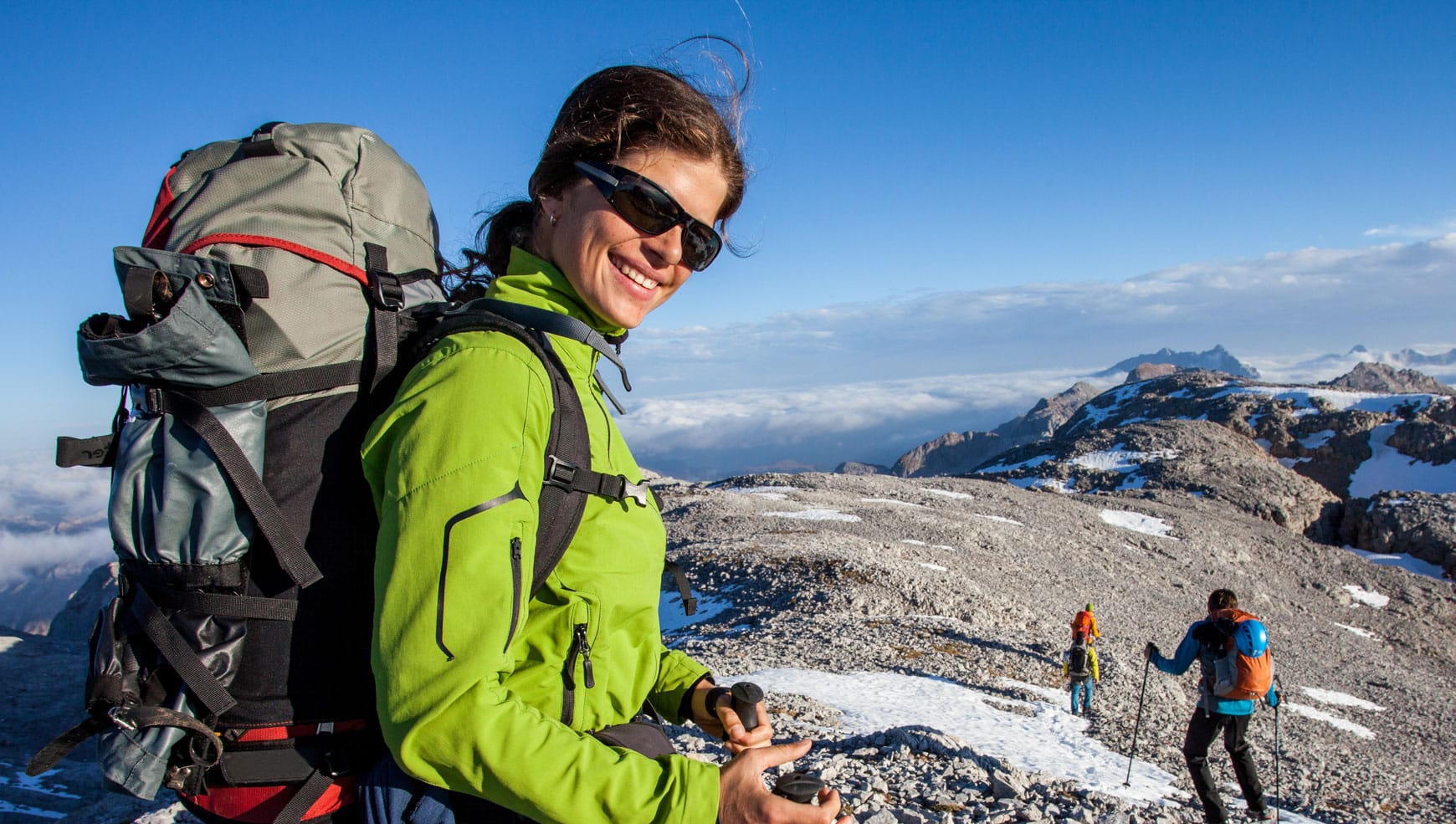 A woman with a backpack on top of a mountain.