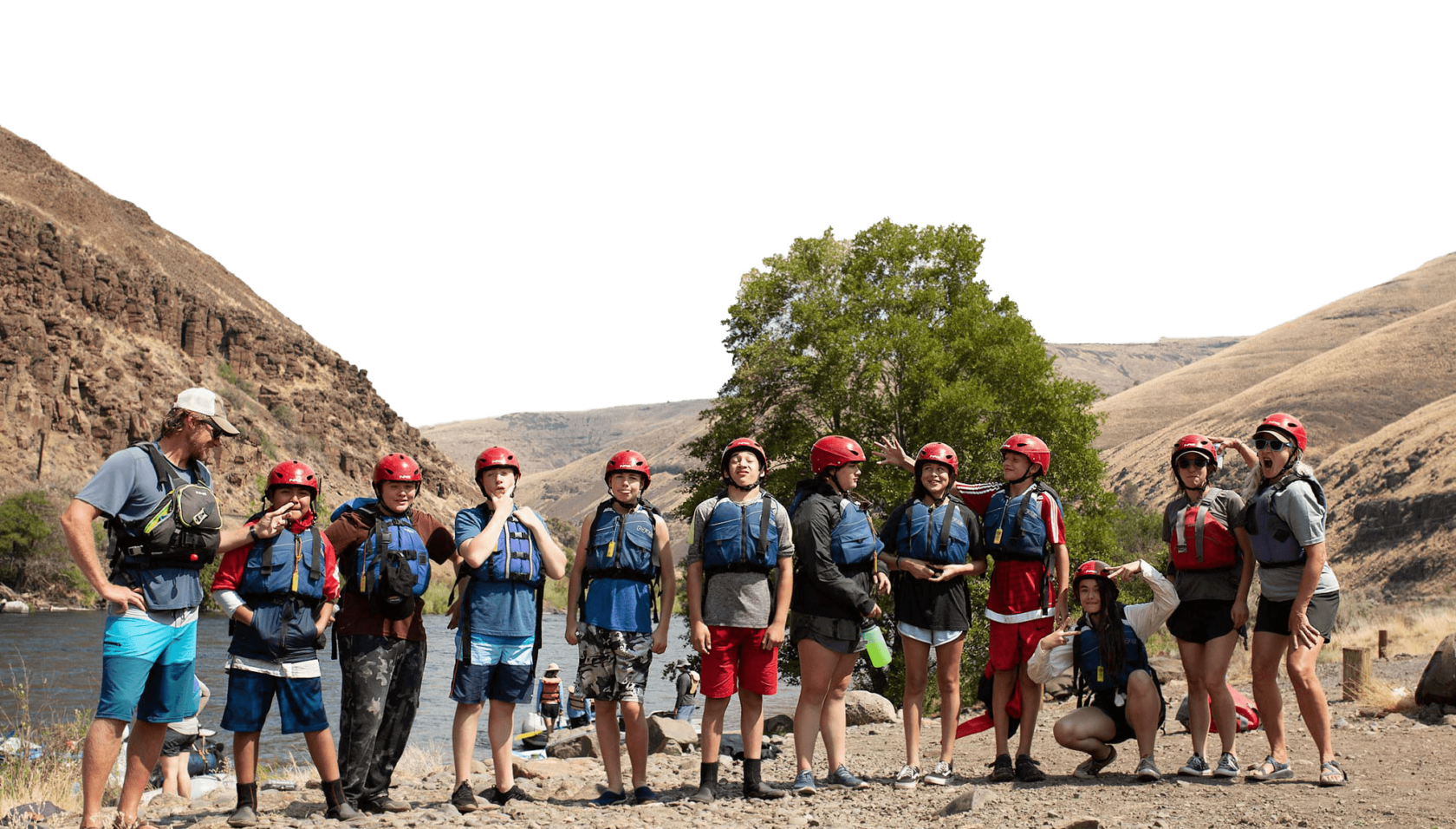 A group of teenagers wearing life jackets and helmets.