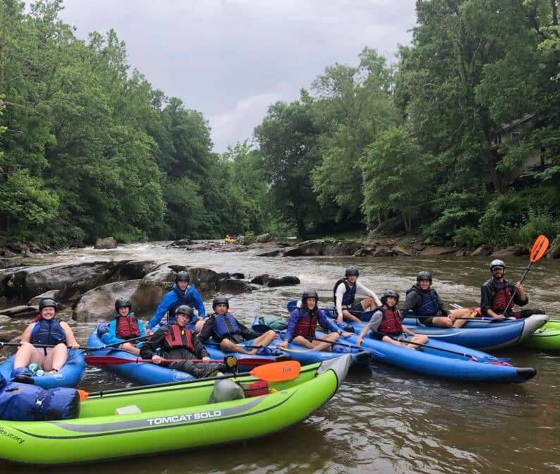 A group of teenagers on inflatable kayaks.