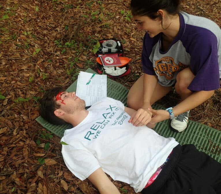 A man lying on a blanket in the woods.