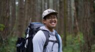 Smiling NCOAE staff member backpacking in the forest.