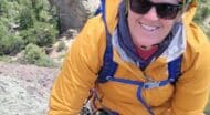 Mandy Goff from NCOAE, smiling at the camera while hiking up a mountain