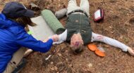 NCOAE wilderness medicine training, with students tending to mock injuries.
