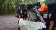 group reading a map in the woods.