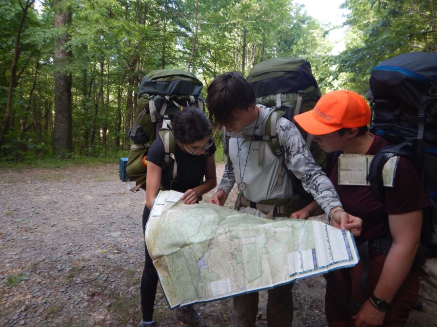 group reading a map in the woods.