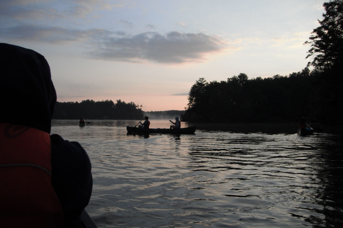 canoe on a lake at sunset.